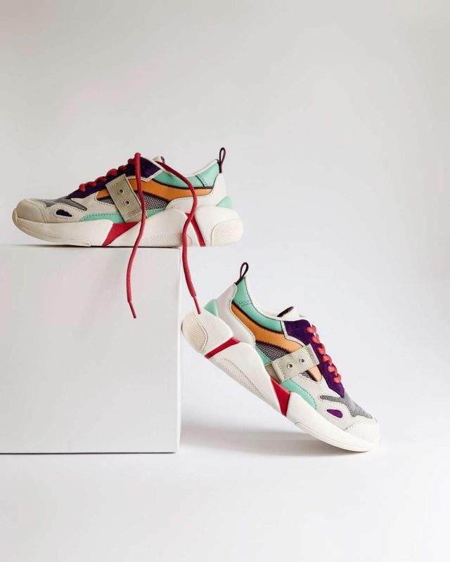 Bunte Sneaker auf einem weißen Podest